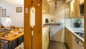 A compact kitchen with a coffee machine, a sink, and wooden cabinets. - 50m from resort center, 6th floor, balcony, 40m², Les Arcs (Les Arcs)