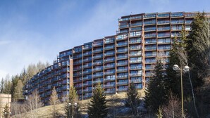 A multi-story hotel with balconies, surrounded by trees and a clear sky. - 50m from resort center, 6th floor, balcony, 40m², Les Arcs (Les Arcs)