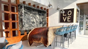 Un espace de détente moderne avec un mur en marbre, des étagères en bois et un comptoir de bar.