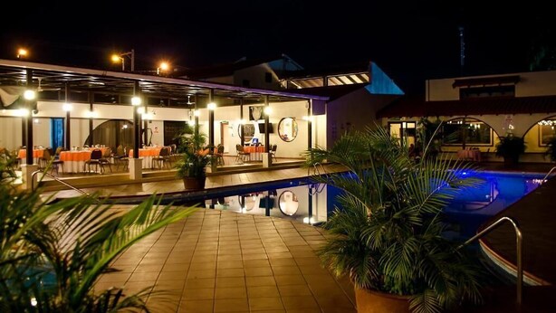 Un hôtel doté d’une piscine, d’un espace extérieur aménagé et d’une terrasse couverte.