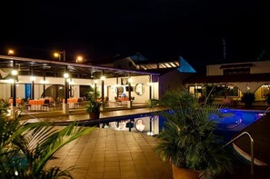 A hotel with a pool area, outdoor seating, and a covered patio. - Hotel Alameda (Tegucigalpa)