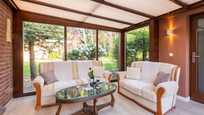 A cozy room with two sofas facing a large window overlooking a garden. - Exclusive vacation home in the Dichterviertel (Brück)