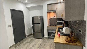Eine moderne Küche mit Kühlschrank, Backofen, Mikrowelle und einer Holzarbeitsplatte.