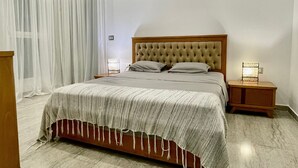 Ein modernes Schlafzimmer mit einem großen Bett, einem hölzernen Kopfteil, einem Nachttisch mit Lampe und einer Decken-Klimaanlage.