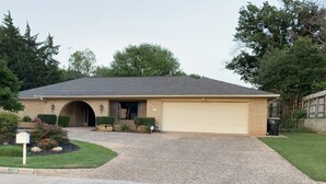 A single-story house with a garage, a driveway, and a well-maintained lawn. - Country Club Casa the Golfer's Getaway!!! (Duncan)