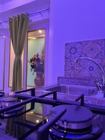 Una cucina moderna con piano cottura a gas, lavello in acciaio inossidabile e zoccolo decorativo.