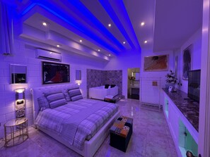 A modern bedroom with a large bed, a vanity, and a television. - GianLuis Luxury Suites (Fasano)
