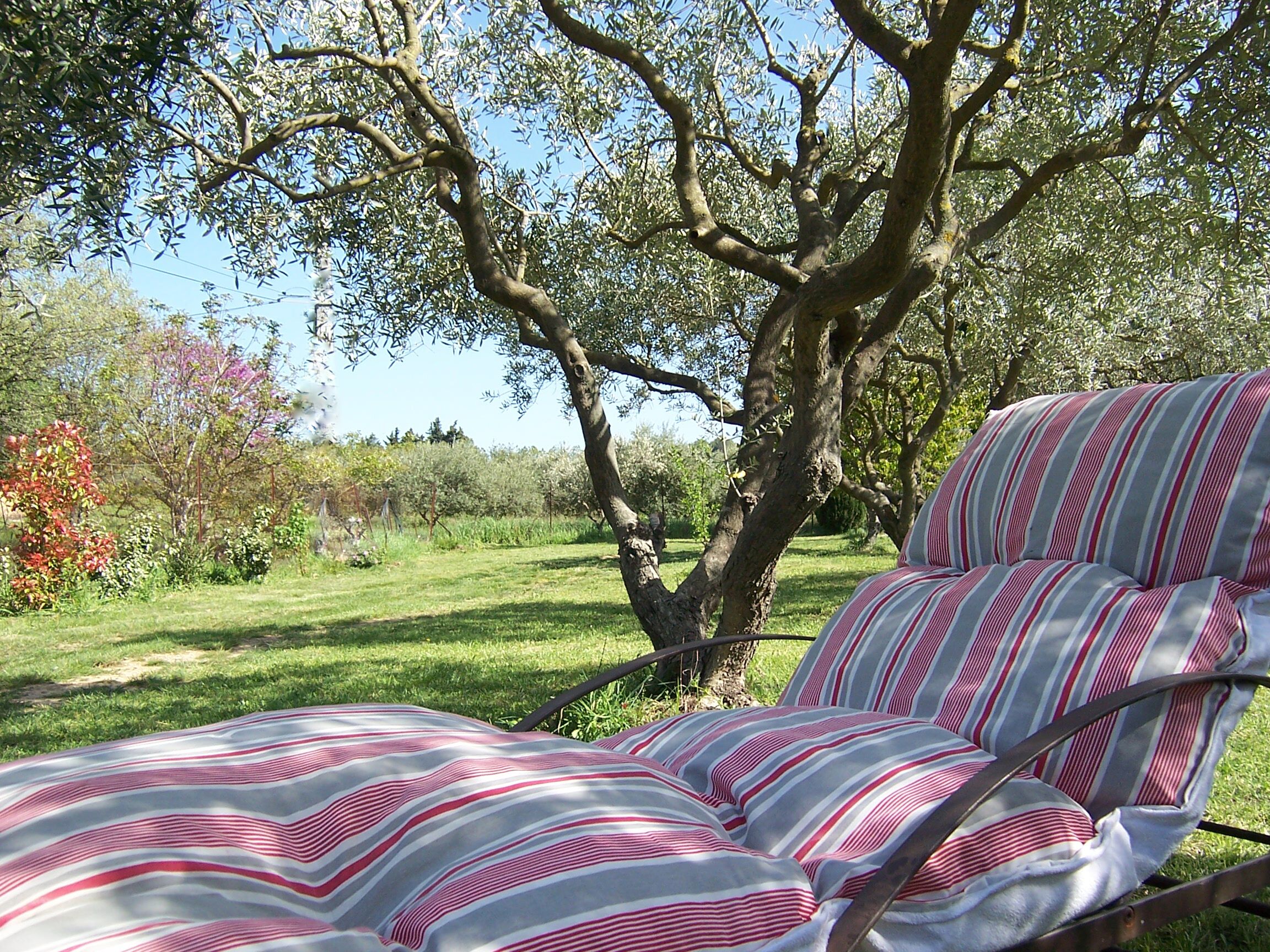 Cama com roupa de cama listrada em um jardim.