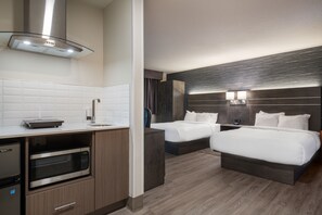 A hotel room with a kitchenette, two beds, a large mirror, and a modern design. - Glengarry Extended Stays (Truro)