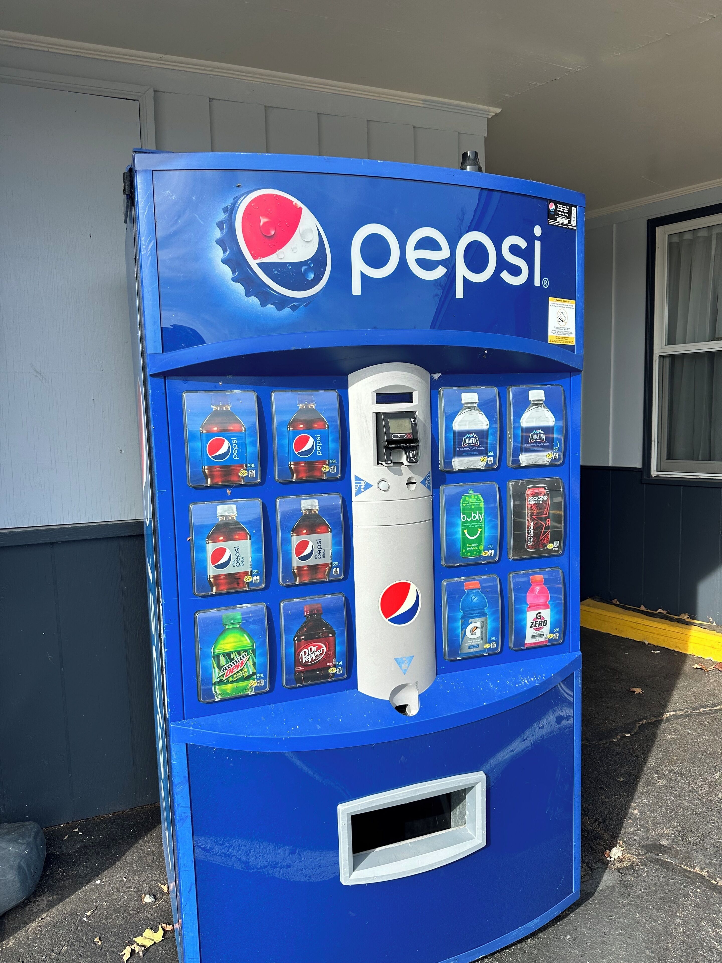 A blue Pepsi vending machine with various drink options.