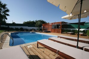 A swimming pool with wooden deck loungers and a small wooden structure with a roof. - Quinta de São Tomé (Évora)