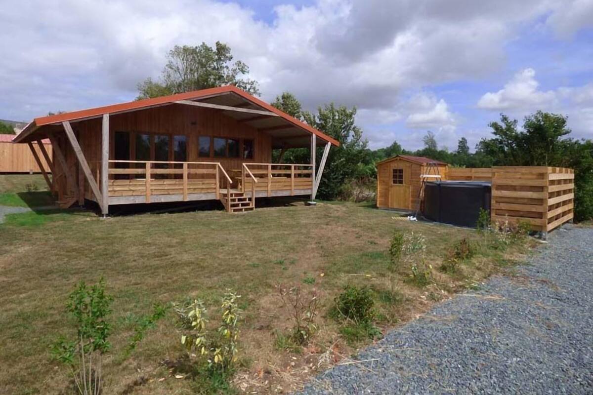 Une cabane en bois avec une véranda et un petit abri de jardin.
