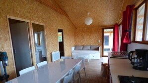 A compact room with a kitchenette, a bed, and a dining area with chairs. - Le Carbet Vendéen (Bouille-Courdault)
