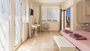 Een slaapkamer met een bed, een bureau, een stoel en een televisie.