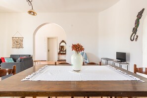 Relax in a spacious living area with a dining table, sofa, and TV.