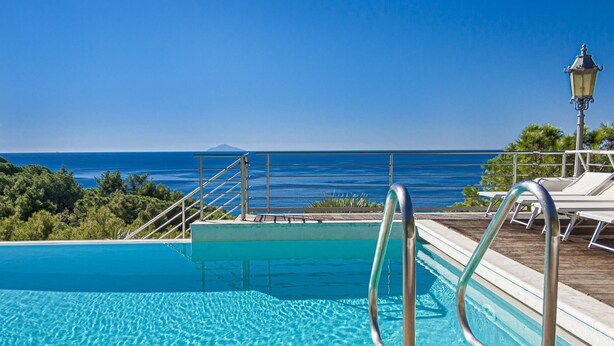 A clear blue pool with a view of the ocean and a mountain in the distance. - Villa Ritter - VILLA RITTER MARIA (Marina di Campo)