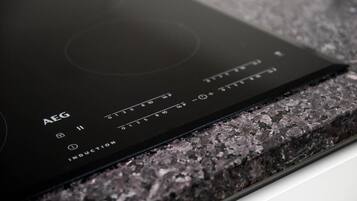 A black induction cooktop with control buttons and a digital display.