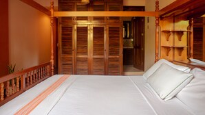 Une chambre à coucher avec un lit à baldaquin en bois, une grande armoire et un luminaire suspendu.
