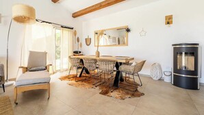 Ein Essbereich mit einem Holztisch, Stühlen, einem großen Spiegel und einem modernen Herd.