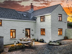 A two-story house with a gravel driveway and a patio area.