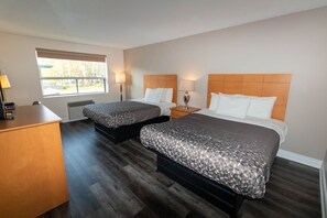 A hotel room with two beds, a wooden desk, and a window with blinds. - Borden Inn & Suites (Essa)