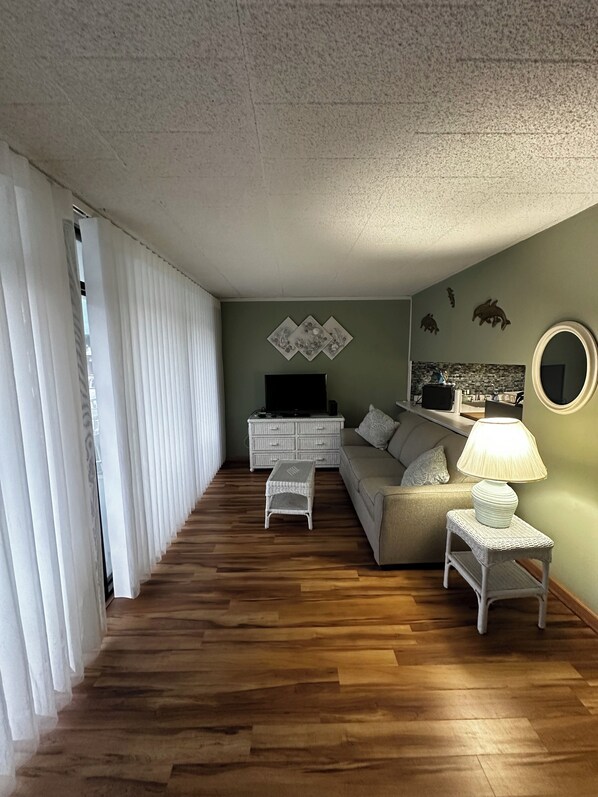 A living room with a sofa, TV, and decorative wall art.
