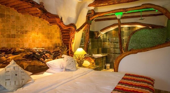 Una habitación rústica con una cama, una lámpara y un espacio con ducha.