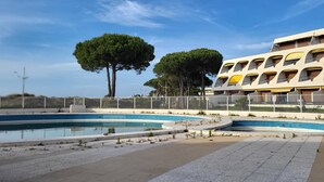 Un edificio moderno con varios balcones y una zona de piscina.