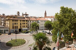 Une place de ville avec des bâtiments, un rond-point et un drapeau.