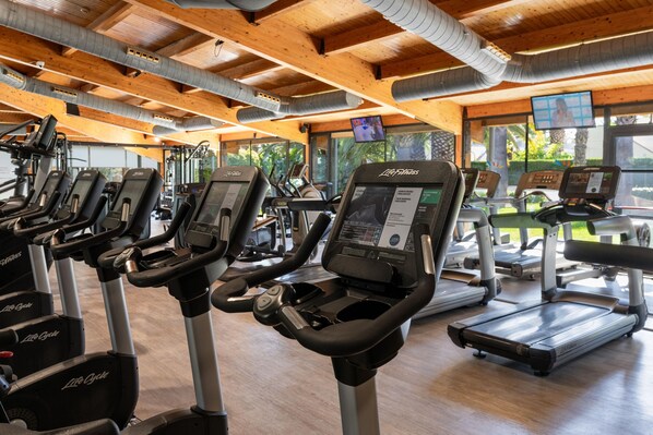 Ein Fitnessstudio mit mehreren Laufbändern, Ergometer und einer Auswahl an Trainingsgeräten.