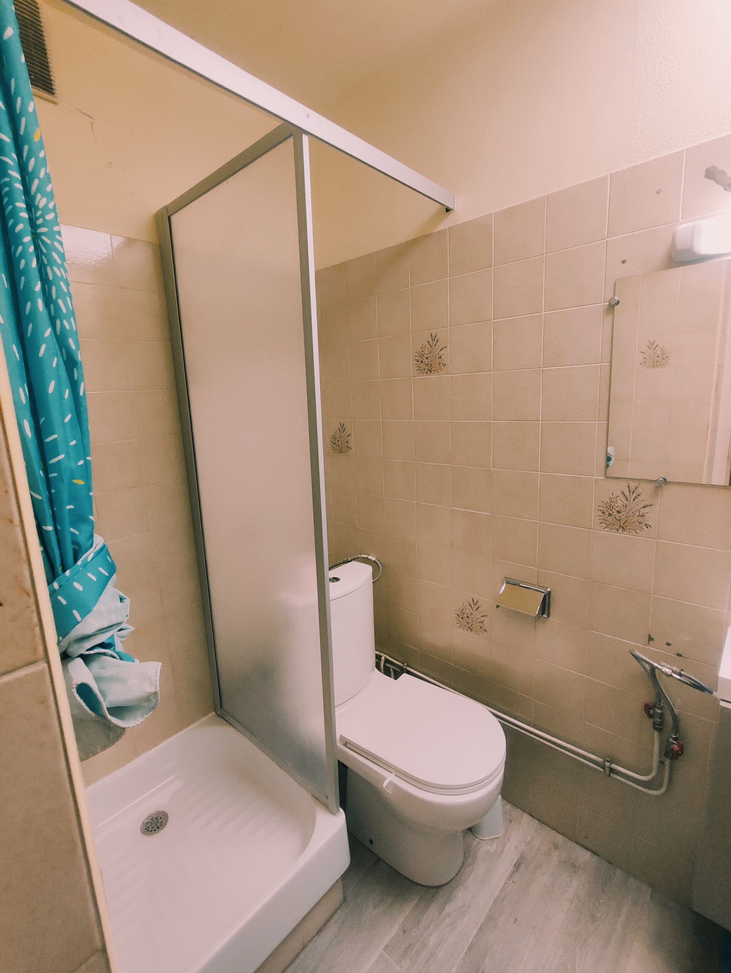 A bathroom with a shower, toilet, and sink.