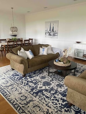 Relax in this stylish living room with a comfortable sofa, coffee table, and dining area.
