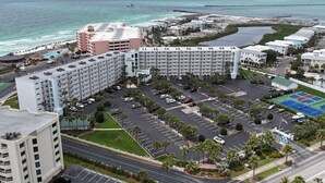 A hotel with multiple floors, a parking lot, and a view of the ocean.