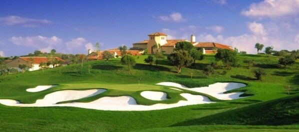A golf course with bunkers and a clubhouse in the background. - Charming, comfortable apartment in a good location (Portimão)