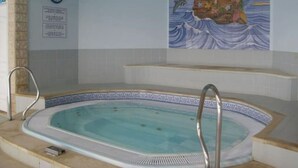 A swimming pool with a tiled edge and a decorative mural on the wall. - Charming, comfortable apartment in a good location (Portimão)