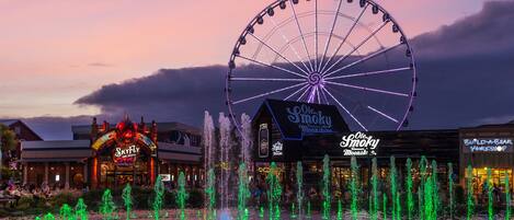 Une zone riveraine comprenant une grande roue, un restaurant SkyFly et un atelier Build-A-Bear.