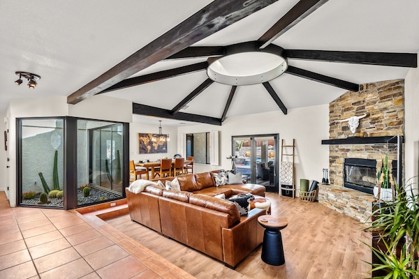 Comfort and luxury in the living room. Fireplace leather couch 75'TV & atrium.