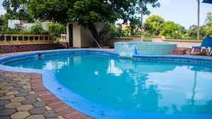 A swimming pool with a tiled edge, a hot tub, and lounge chairs. - Old Cam Lodge (Runaway Bay)