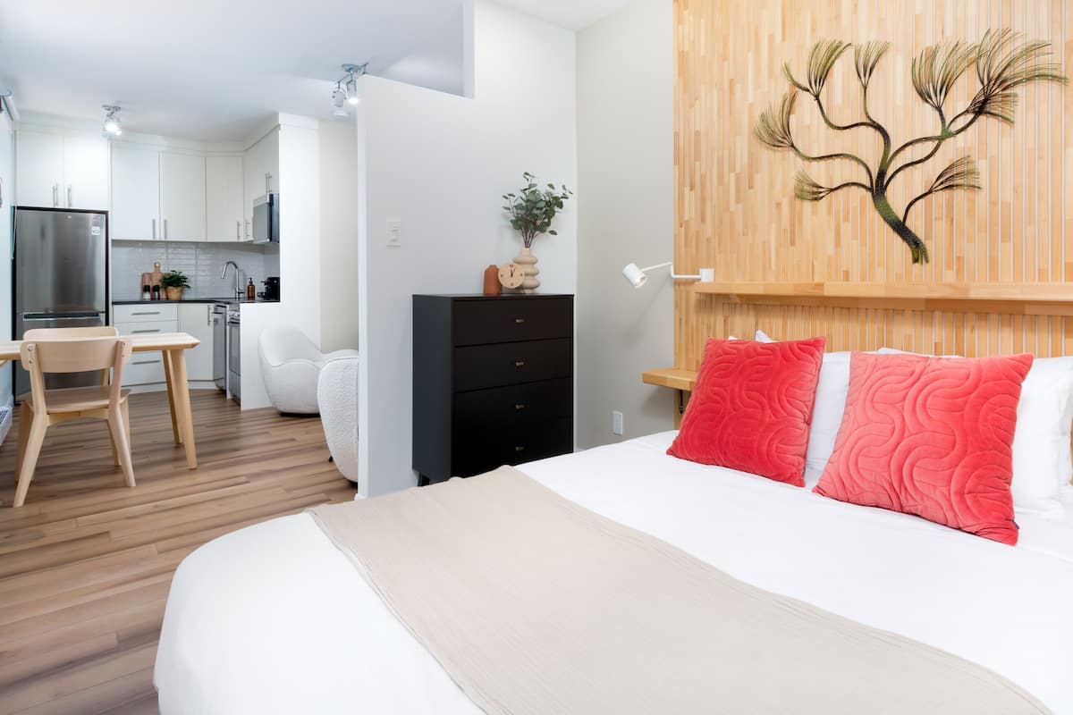 Une chambre d’hôtel moderne équipée d’un lit, d’un bureau et d’une kitchenette.