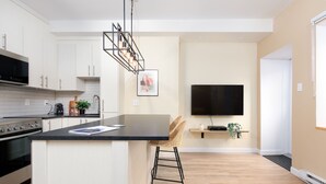 A modern kitchen with white cabinets, a black countertop, and a built-in oven.