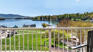 Une vue sur le lac depuis un balcon, avec une pelouse, un quai et un kiosque.