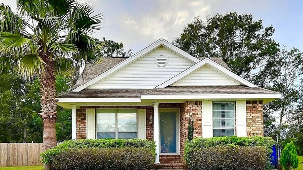 A single-story house with a gabled roof, a front porch, and a brick facade. - Cozy and relaxing beach house, Our Little Pearl in Foley. (Foley)