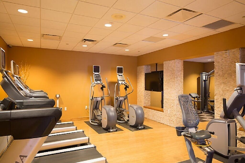 A gym with treadmills, elliptical machines, and a stationary bike.