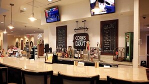 Zona de bar con mostrador, taburetes y cartelera de menú.