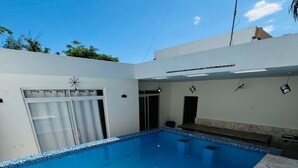 A rectangular swimming pool with a clear blue water surface, surrounded by a tiled deck. - Private pool ,  2 bedroom boho villa (Juan Dolio)