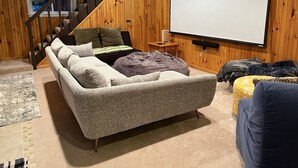 Un salon confortable avec un canapé, une table basse, un téléviseur et un escalier.