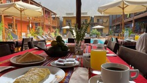 A breakfast setting with a plate of toast, a bowl of fruit, a glass of orange juice, and a cup of coffee. - VPX HOTEL & Bungalows (Cieneguilla)