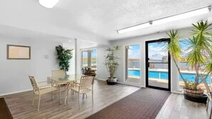 A spacious room with a dining area, large windows, and a view of a pool. - Fantastic Water View From Deck  (Osage Beach)
