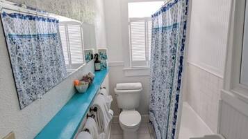 A bathroom with a toilet, sink, and shower curtain.