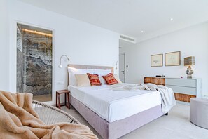 A modern bedroom with a large bed, a wooden headboard, a bedside table, and a mirror. - Exquisite design villa directly at the bach (Blato)